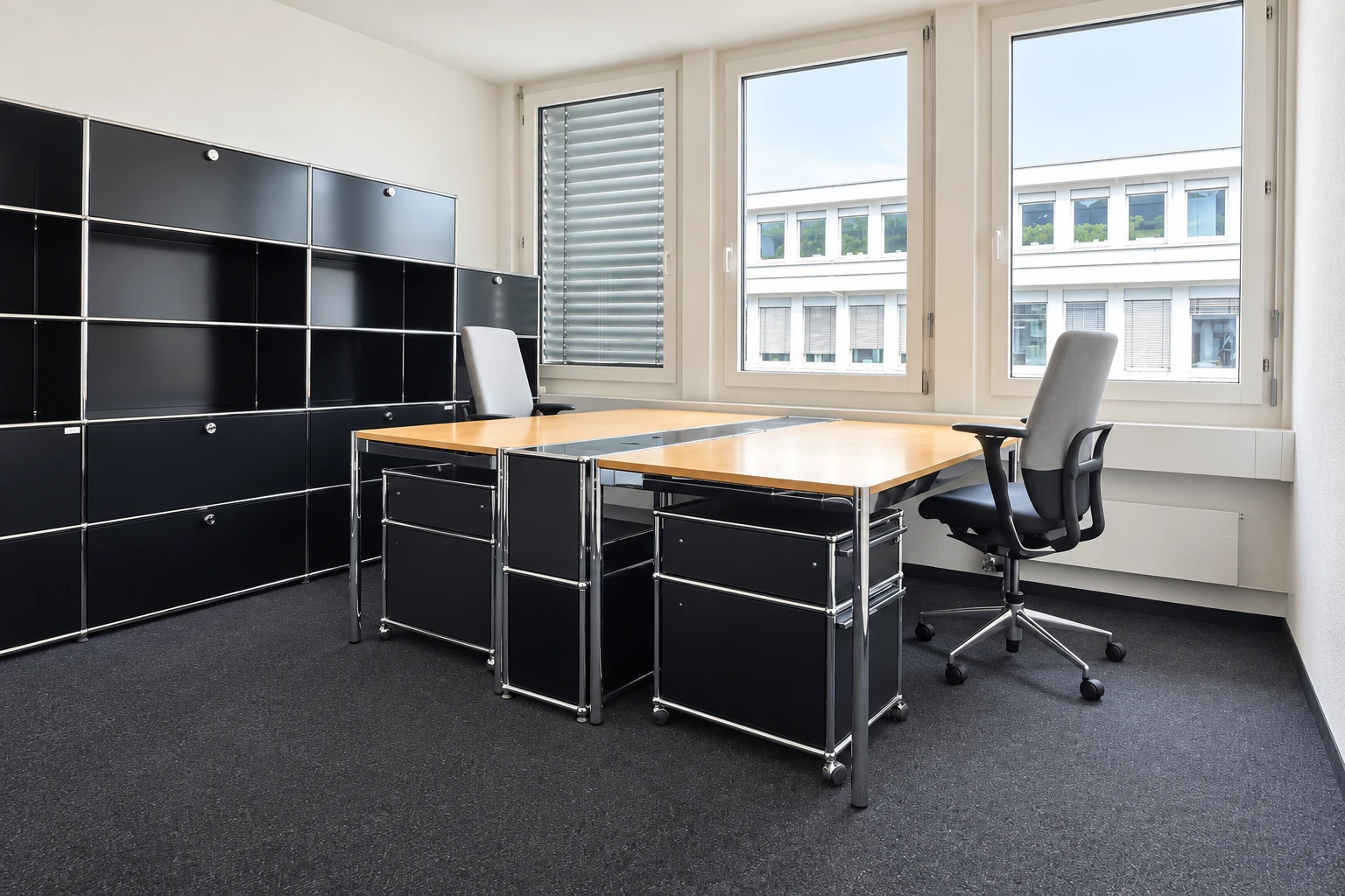 Privatbüro mit zwei Holzschreibtischen, grauen Bürostühlen und Tageslicht